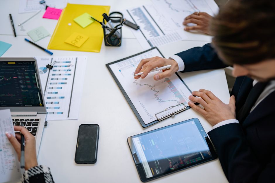 Equipo revisando gráficos financieros y datos digitales en tablets.