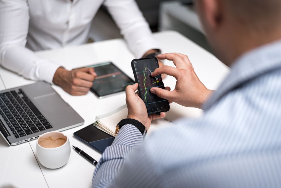 Profesionales usando smartphones y tablets analizando gráficos